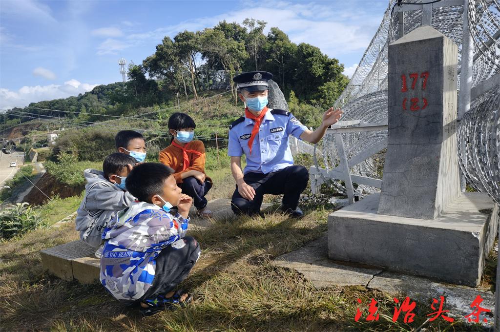 图为云南出入境边防检查总站优秀共青团员、雪林所民警张发刚在中缅177界桩旁给孩子生动讲述了移民管理故事.jpg